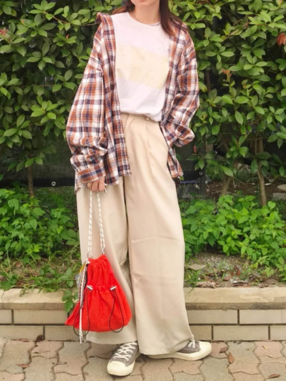 グレー系のTシャツ/カットソー、レッド系のシャツ/ブラウス、ホワイト系のスラックスを着用したレディースの秋コーディネートの2枚目の写真