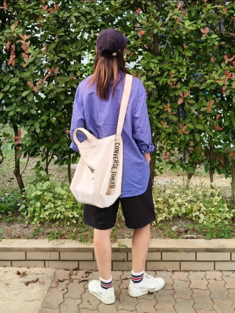 ブルー系のシャツ/ブラウス、ホワイト系のスニーカー、ホワイト系のトートバッグを着用したレディースの秋コーディネートの4枚目の写真