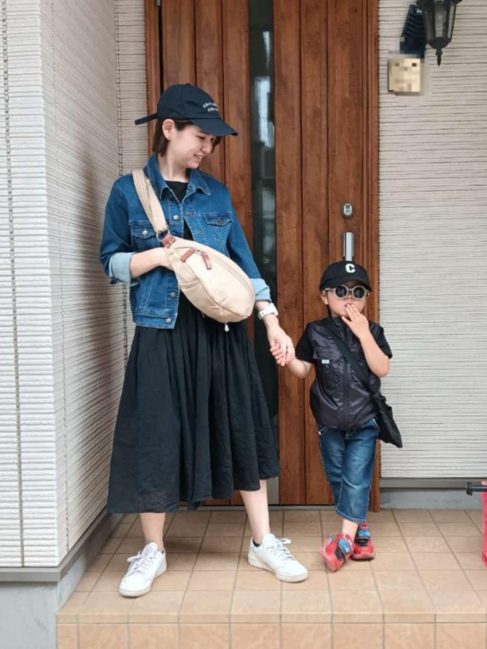 ブルー系のデニムジャケット、ベージュ系のショルダーバッグ、ホワイト系のスニーカーを着用したレディースの春コーディネートの5枚目の写真