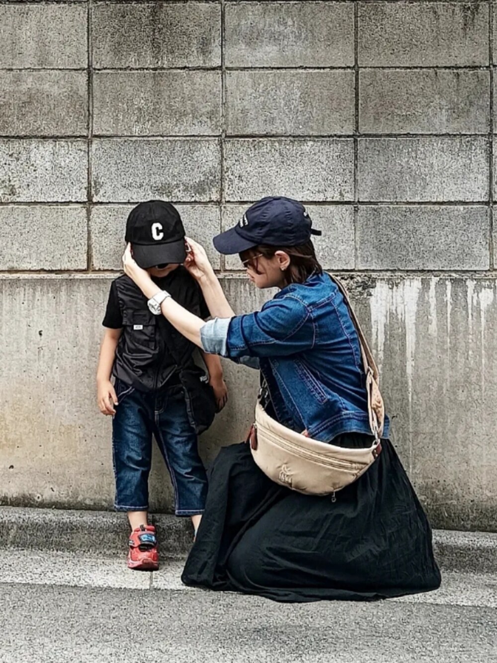 ブルー系のデニムジャケット、ベージュ系のショルダーバッグ、ホワイト系のスニーカーを着用したレディースの春コーディネートの3枚目の写真