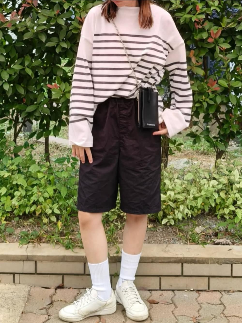 ホワイト系のTシャツ/カットソー、ブラック系のショルダーバッグ、ブラック系のその他パンツを着用したレディースの秋コーディネートの2枚目の写真