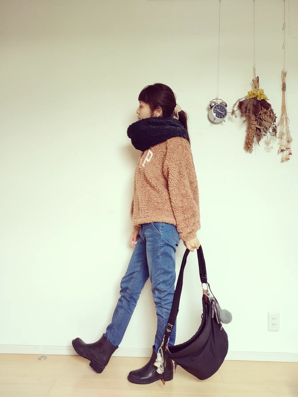 ブラック系のバッグ、ブラック系のレインシューズ、ブルー系のデニムパンツを着用したレディースの秋コーディネートの5枚目の写真