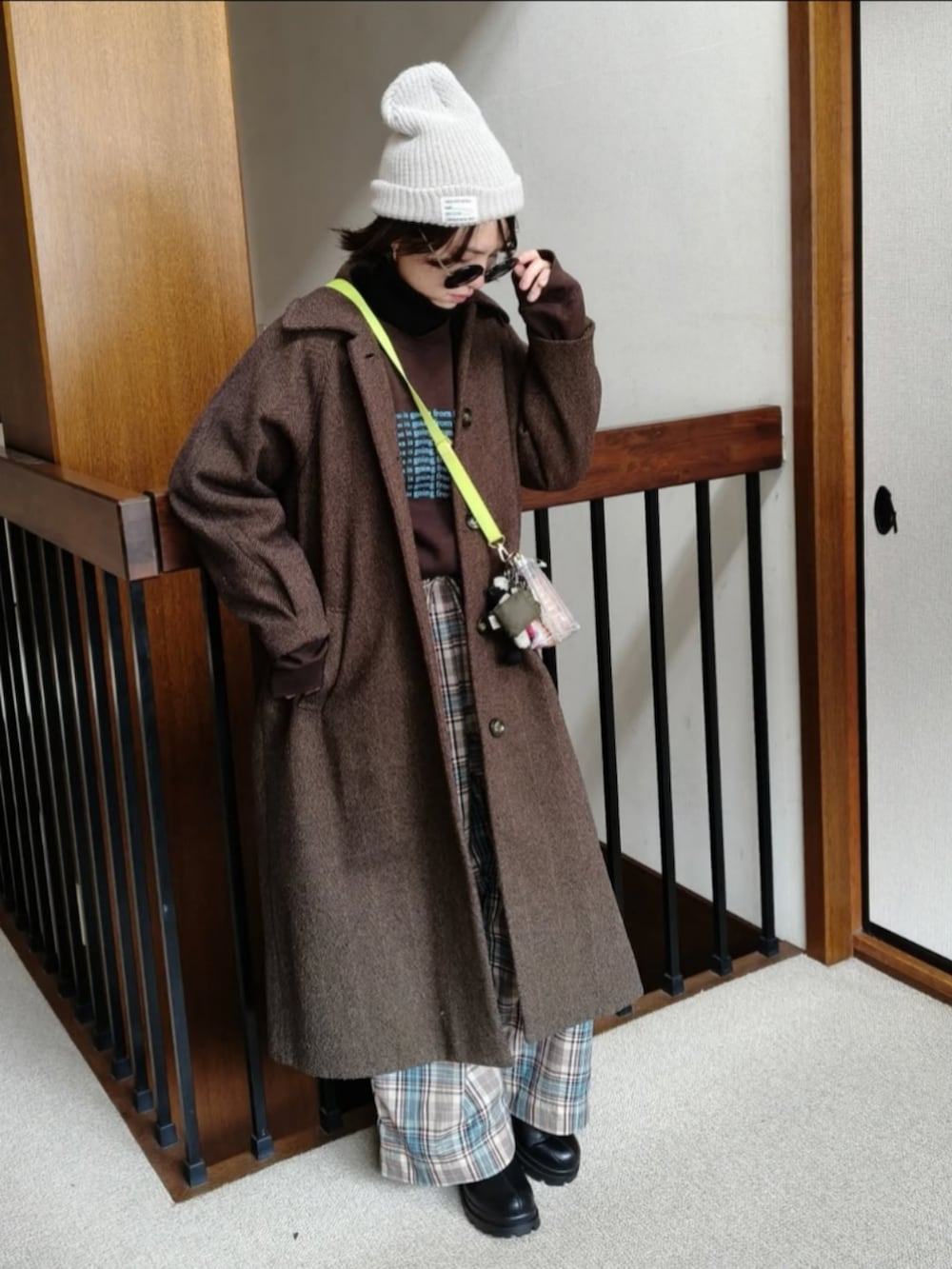 ブラウン系のスウェット、ブラウン系のその他アウター、ホワイト系のショルダーバッグを着用したレディースの冬コーディネートの2枚目の写真