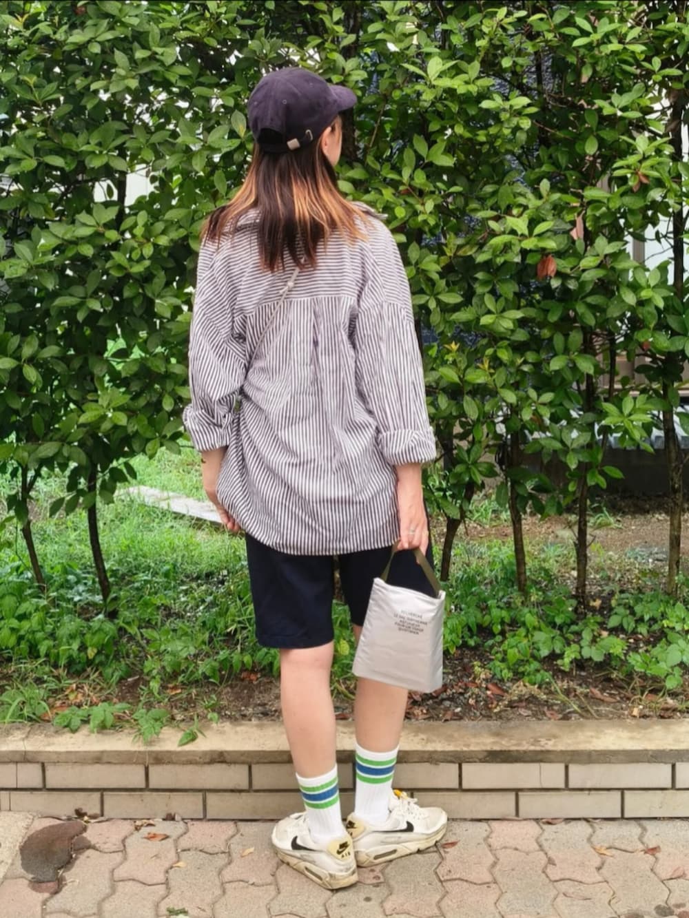 ホワイト系のTシャツ/カットソー、グレー系のショルダーバッグ、ブルー系のシャツ/ブラウスを着用したレディースの秋コーディネートの2枚目の写真