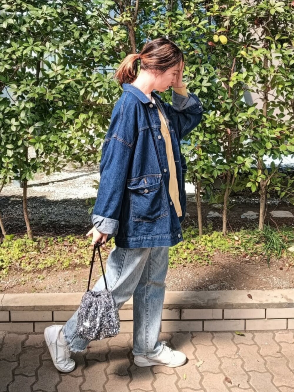 イエロー系のTシャツ/カットソー、グリーン系のカーディガン/ボレロ、ブルー系のデニムジャケットを着用したレディースの春コーディネートの2枚目の写真