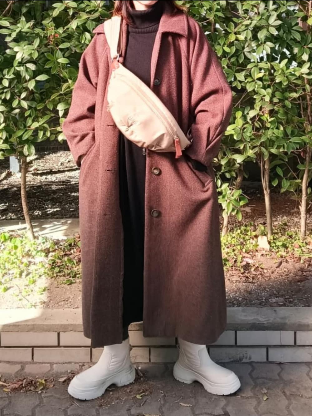 ベージュ系のショルダーバッグ、ブラウン系のその他アウター、ブラック系のワンピースを着用したレディースの冬コーディネートの3枚目の写真