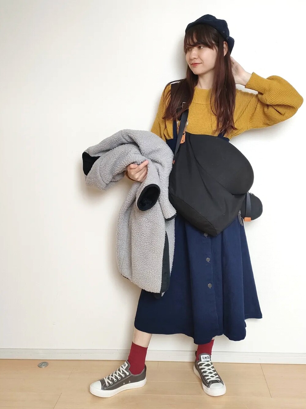 イエロー系のニット/セーター、ブルー系のその他アウター、ブラック系のバッグを着用したレディースの冬コーディネートの2枚目の写真