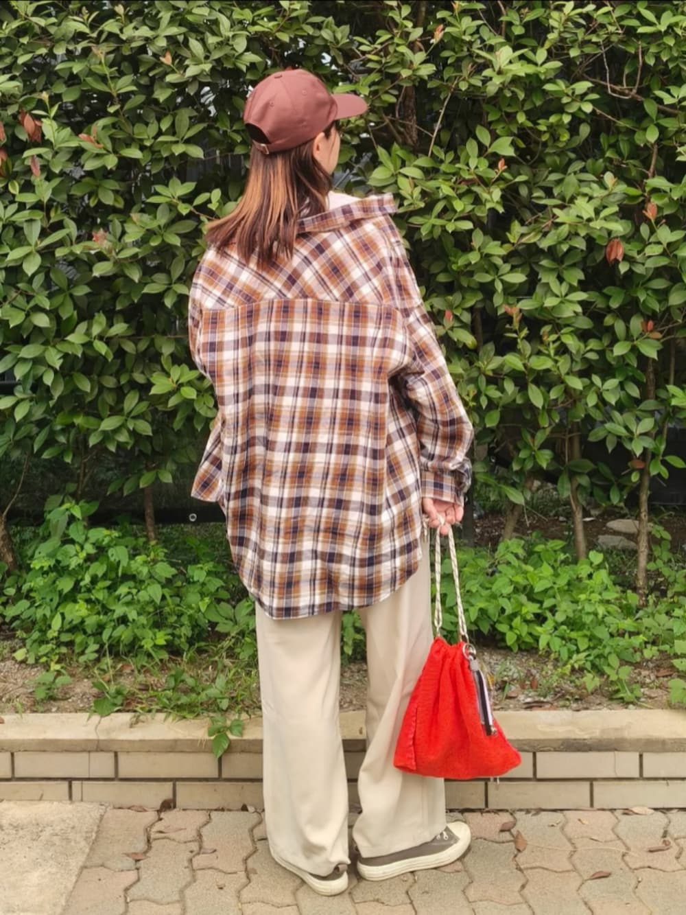 グレー系のTシャツ/カットソー、レッド系のシャツ/ブラウス、ホワイト系のスラックスを着用したレディースの秋コーディネートの5枚目の写真