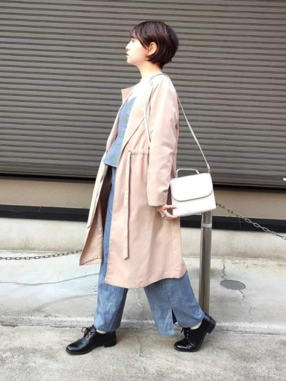 ベージュ系のノーカラーコート、ホワイト系のショルダーバッグ、ブラック系のドレスシューズを着用したレディースの冬コーディネートの2枚目の写真