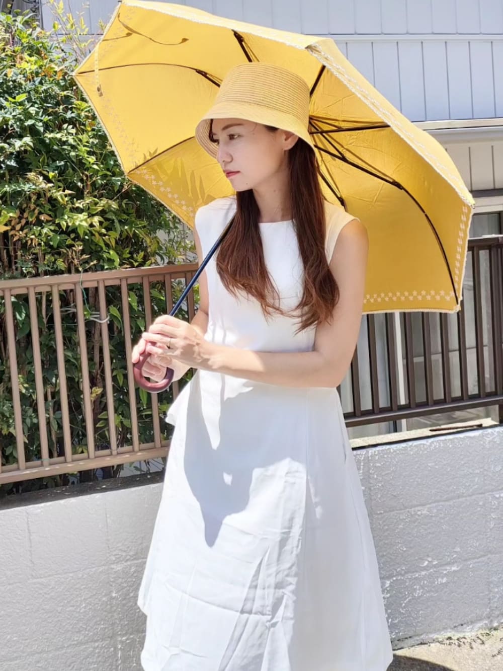 ホワイト系のワンピース、イエロー系のショルダーバッグ、ブラウン系のサンダルを着用したレディースの夏コーディネートの2枚目の写真