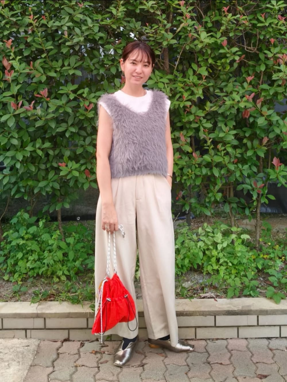 ホワイト系のTシャツ/カットソー、ホワイト系のスラックス、オレンジ系のショルダーバッグを着用したレディースの秋コーディネートの3枚目の写真