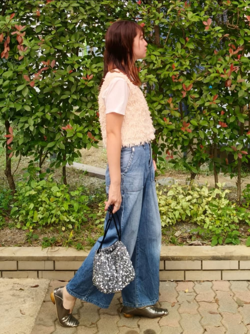 ホワイト系のTシャツ/カットソー、ホワイト系のベスト、ブルー系のデニムパンツを着用したレディースの秋コーディネートの3枚目の写真