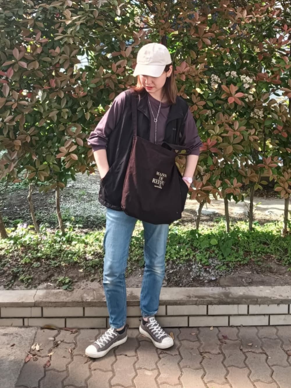 ブラック系のベスト、グレー系のTシャツ/カットソー、ブラック系のトートバッグを着用したレディースの春コーディネートの3枚目の写真