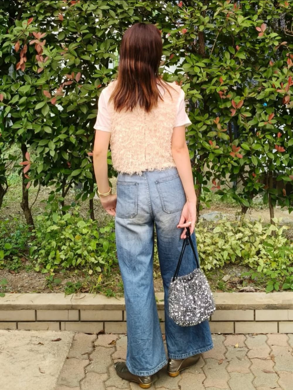 ホワイト系のTシャツ/カットソー、ホワイト系のベスト、ブルー系のデニムパンツを着用したレディースの秋コーディネートの4枚目の写真