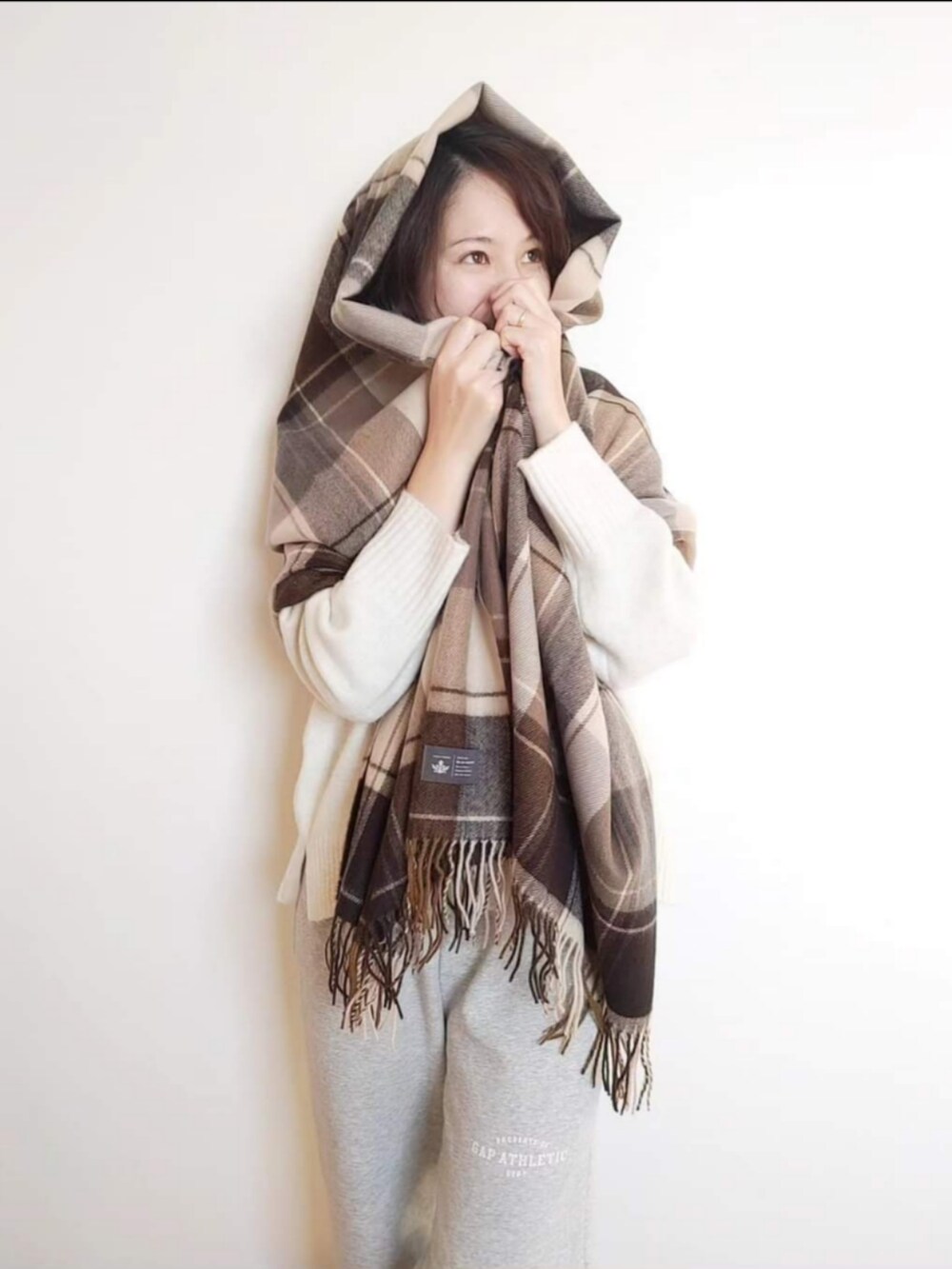 ホワイト系のニット/セーター、グレー系のスウェットパンツ、ベージュ系のストール/ショールを着用したレディースの冬コーディネートの3枚目の写真