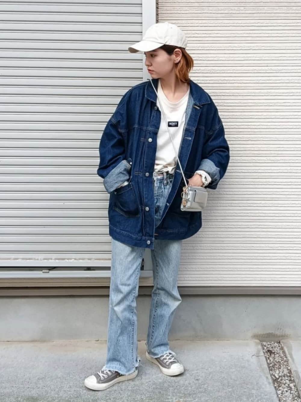 ホワイト系のTシャツ/カットソー、ブルー系のデニムジャケット、グレー系のショルダーバッグを着用したレディースの秋コーディネートの3枚目の写真