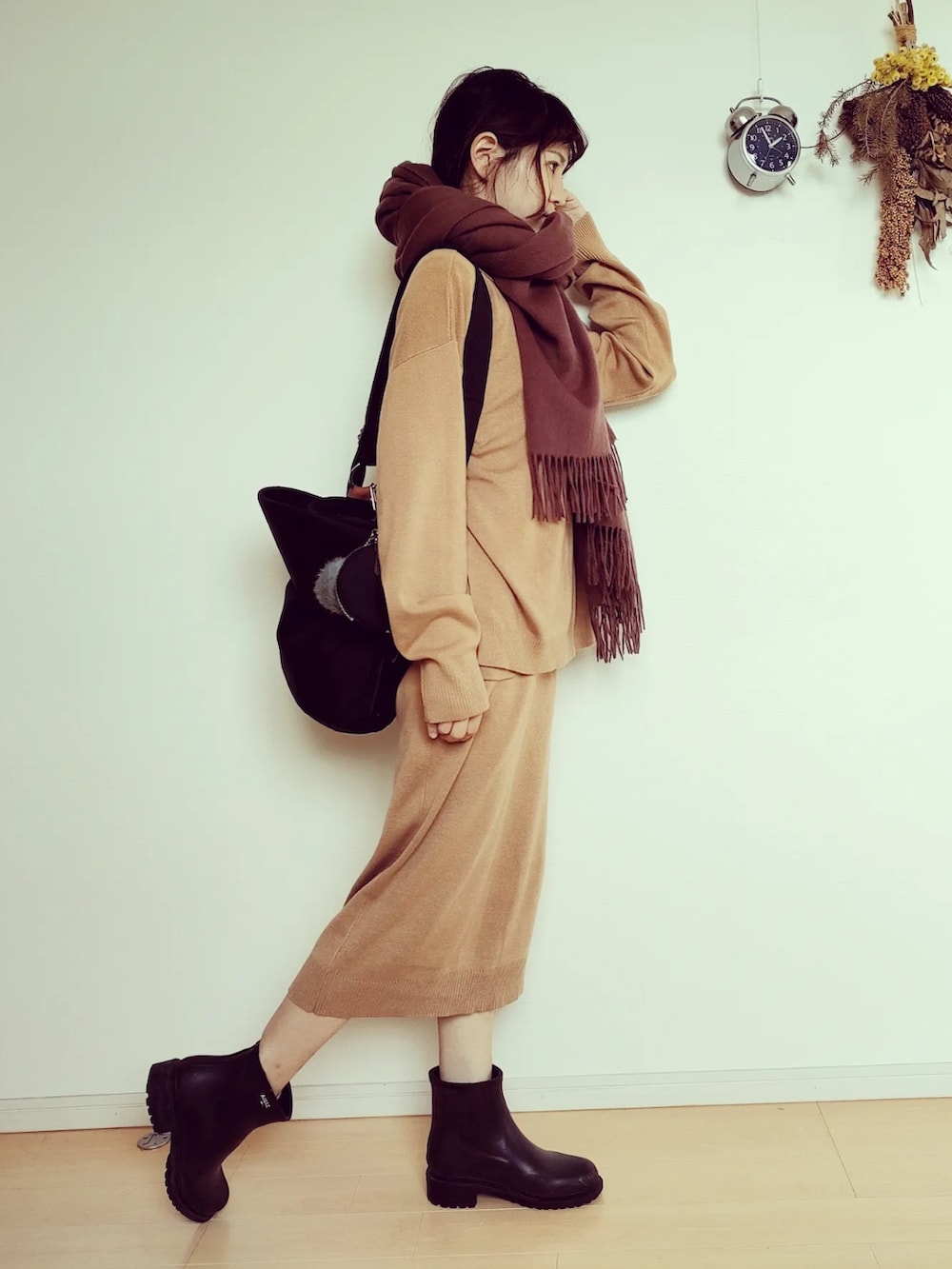 ブラック系のバッグ、ブラック系のレインシューズ、ベージュ系のセットアップを着用したレディースの秋コーディネートの5枚目の写真