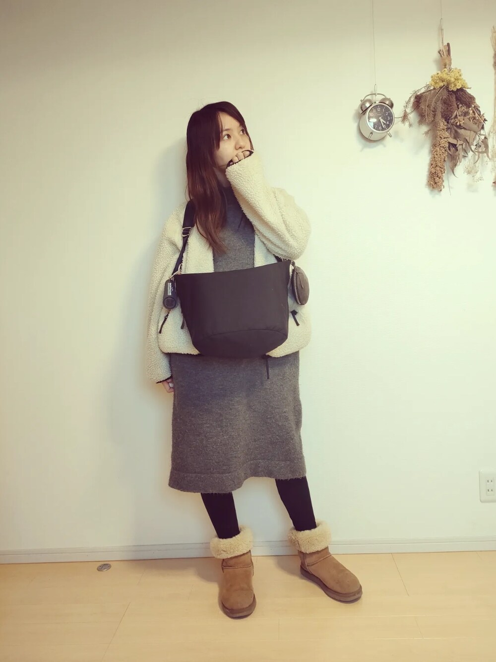 グレー系のワンピース/ドレス、ホワイト系のブルゾン、ブラック系のバッグを着用したレディースの冬コーディネートの2枚目の写真