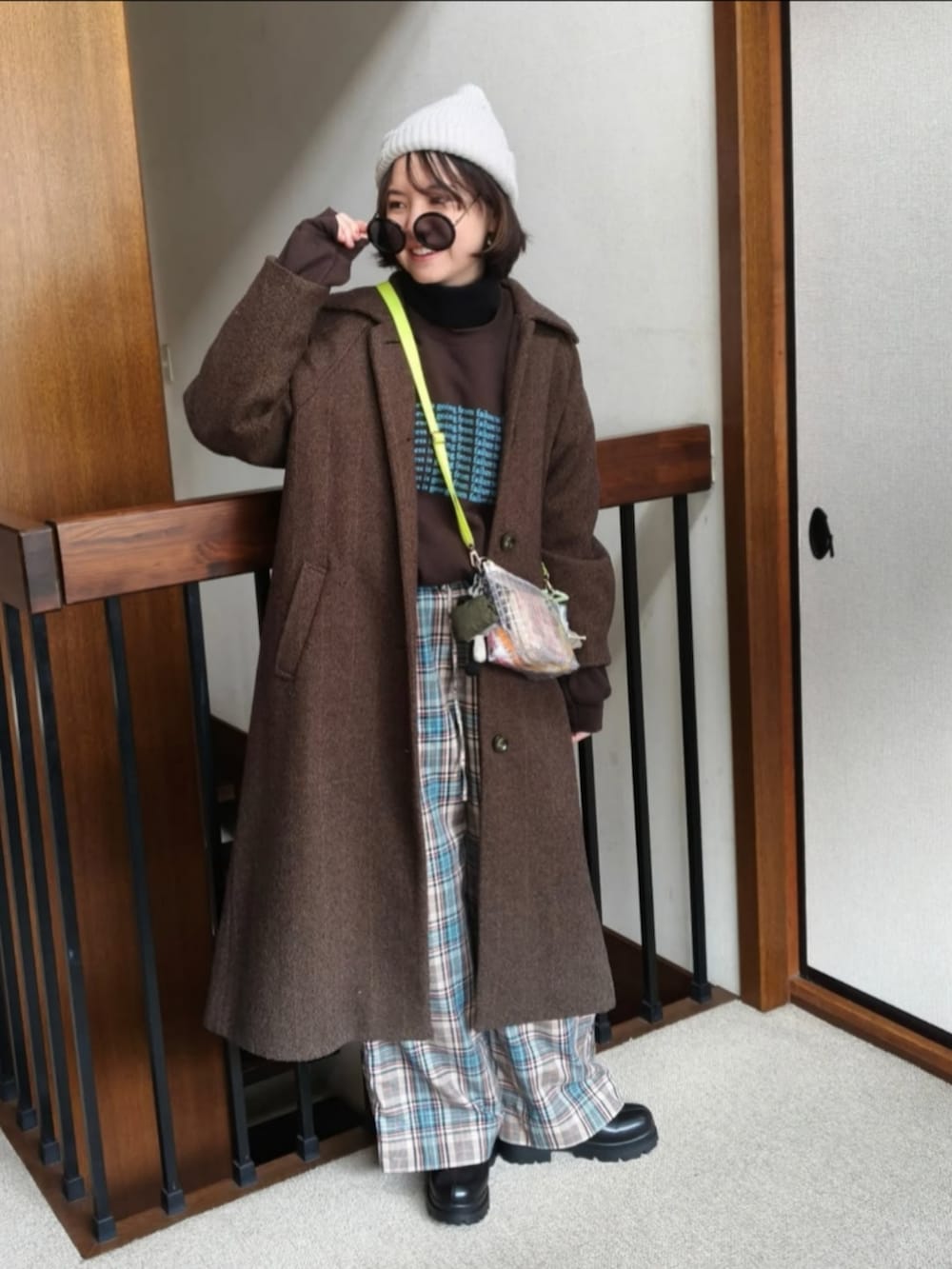 ブラウン系のスウェット、ブラウン系のその他アウター、ホワイト系のショルダーバッグを着用したレディースの冬コーディネートの4枚目の写真