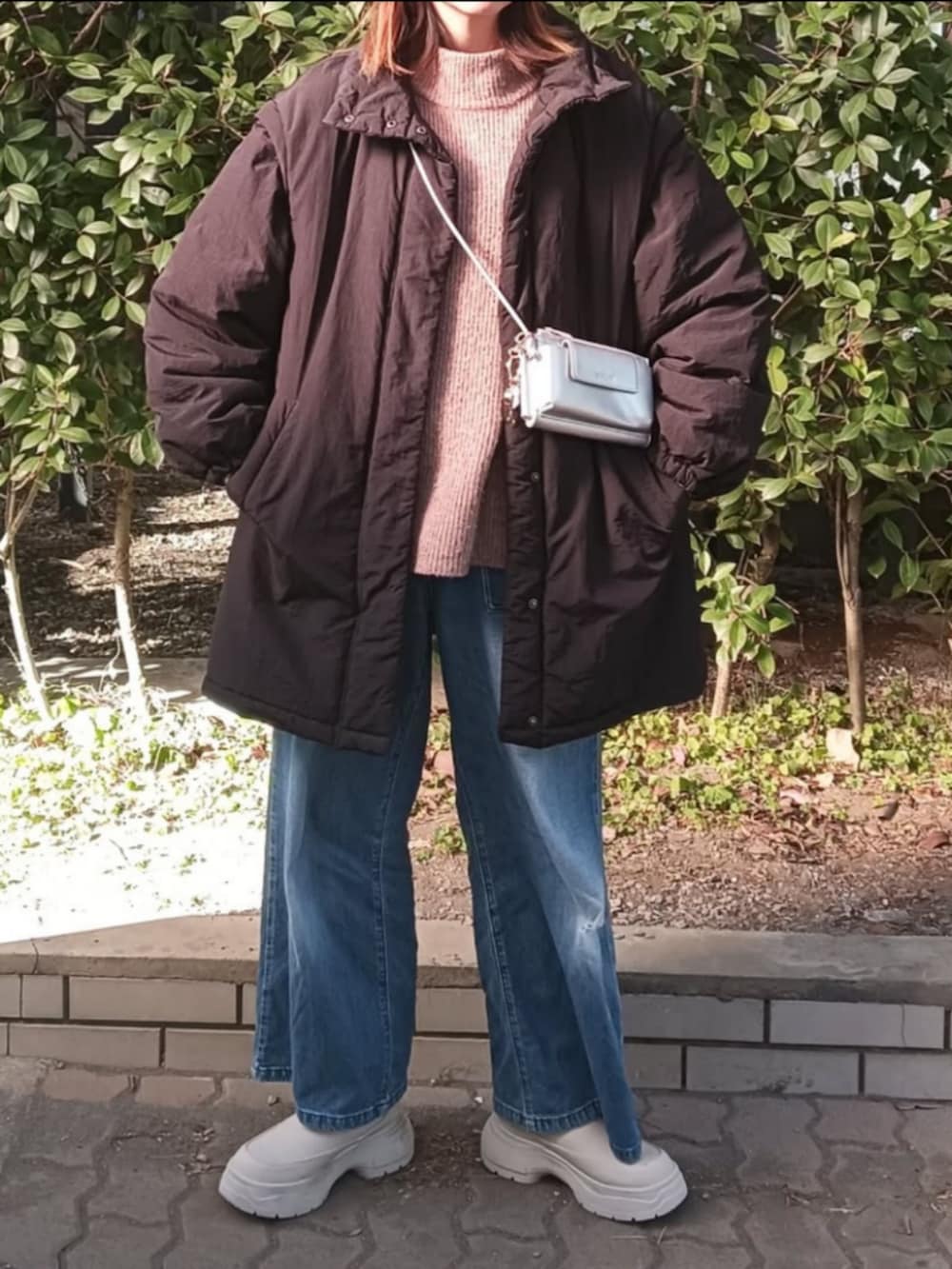 ブラック系のダウンジャケット/コート、ベージュ系のニット/セーター、ベージュ系のブーツを着用したレディースの冬コーディネートの2枚目の写真