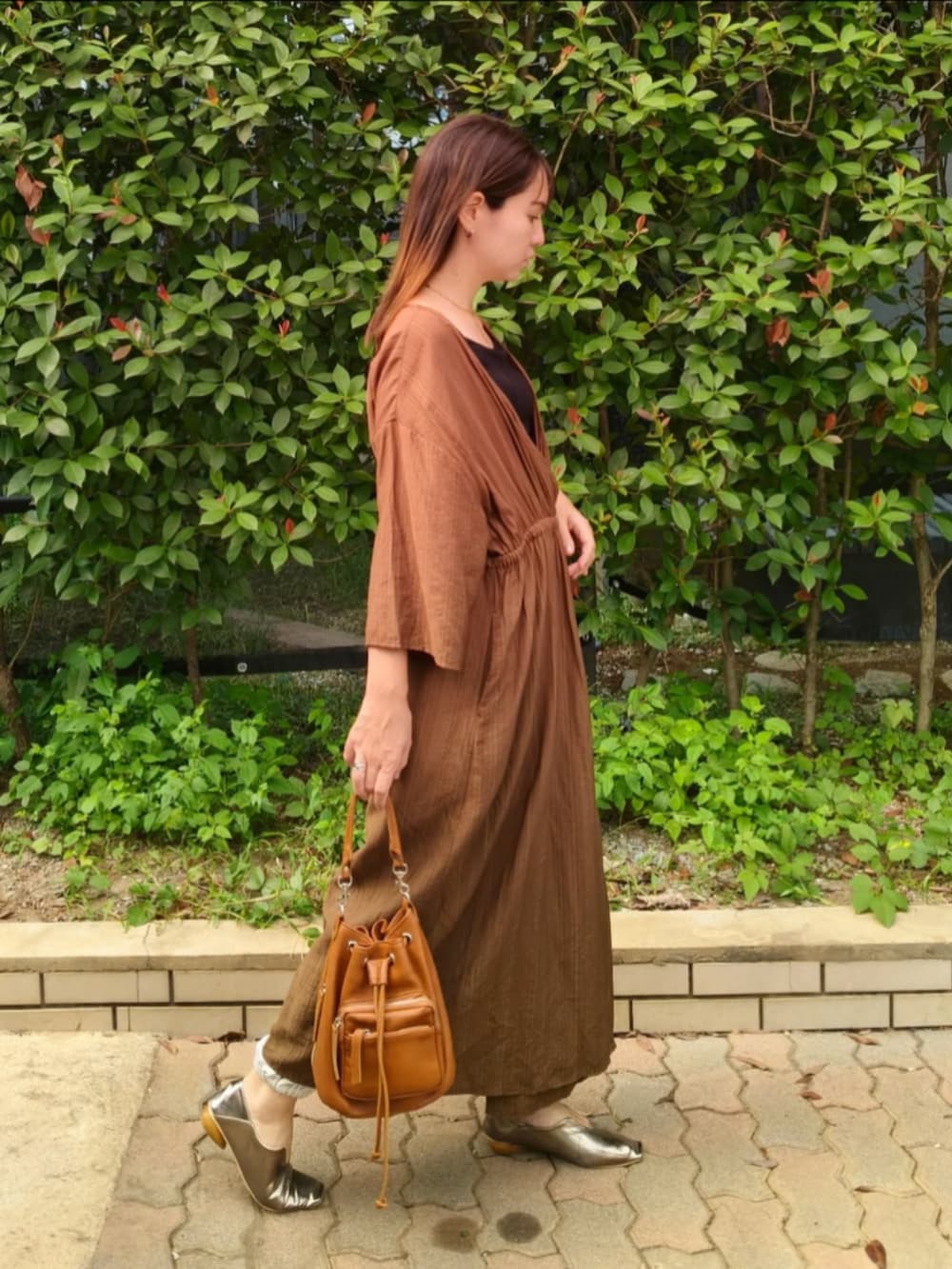 ブラック系のキャミソール、グリーン系のワンピース、ブラウン系のショルダーバッグを着用したレディースの秋コーディネートの3枚目の写真