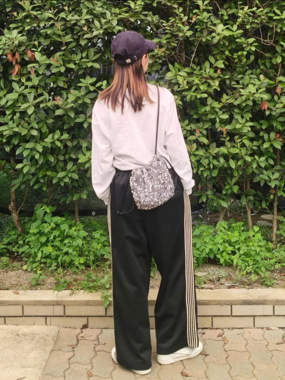 グレー系のTシャツ/カットソー、シルバー系のショルダーバッグ、ブラック系のその他パンツを着用したレディースの秋コーディネートの3枚目の写真