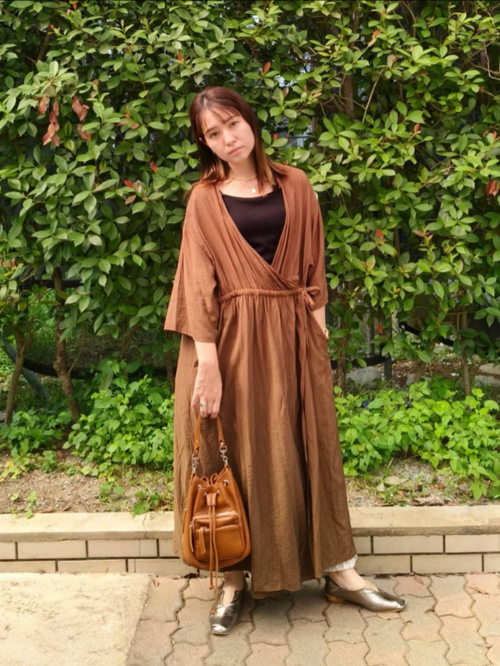 ブラック系のキャミソール、グリーン系のワンピース、ブラウン系のショルダーバッグを着用したレディースの秋コーディネートの5枚目の写真