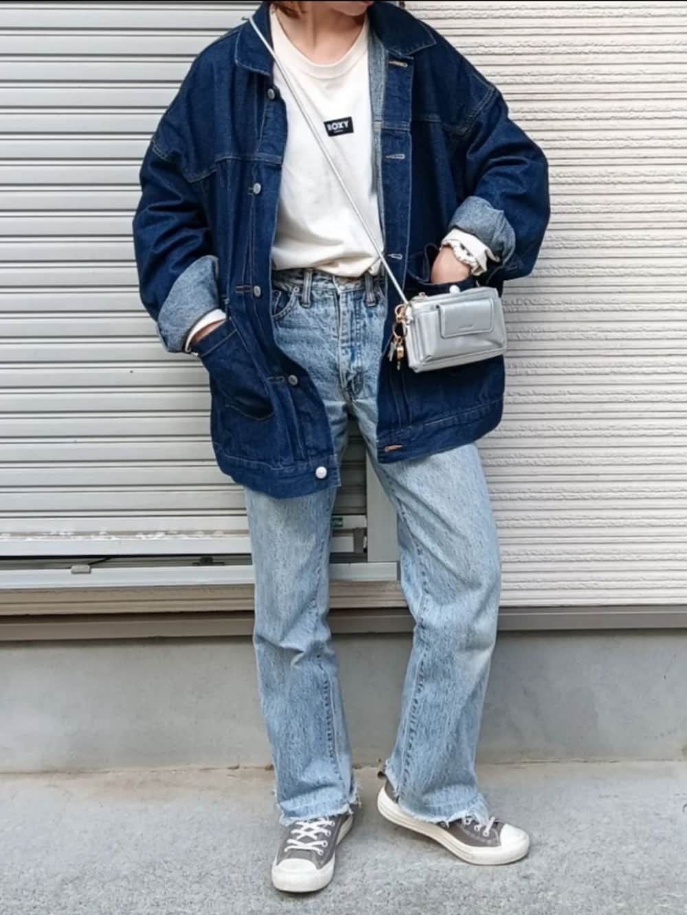 ホワイト系のTシャツ/カットソー、ブルー系のデニムジャケット、グレー系のショルダーバッグを着用したレディースの秋コーディネートの2枚目の写真