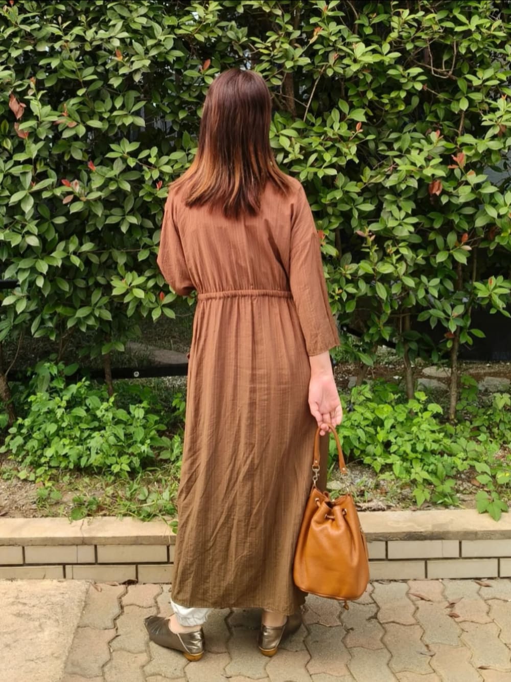 ブラック系のキャミソール、グリーン系のワンピース、ブラウン系のショルダーバッグを着用したレディースの秋コーディネートの4枚目の写真