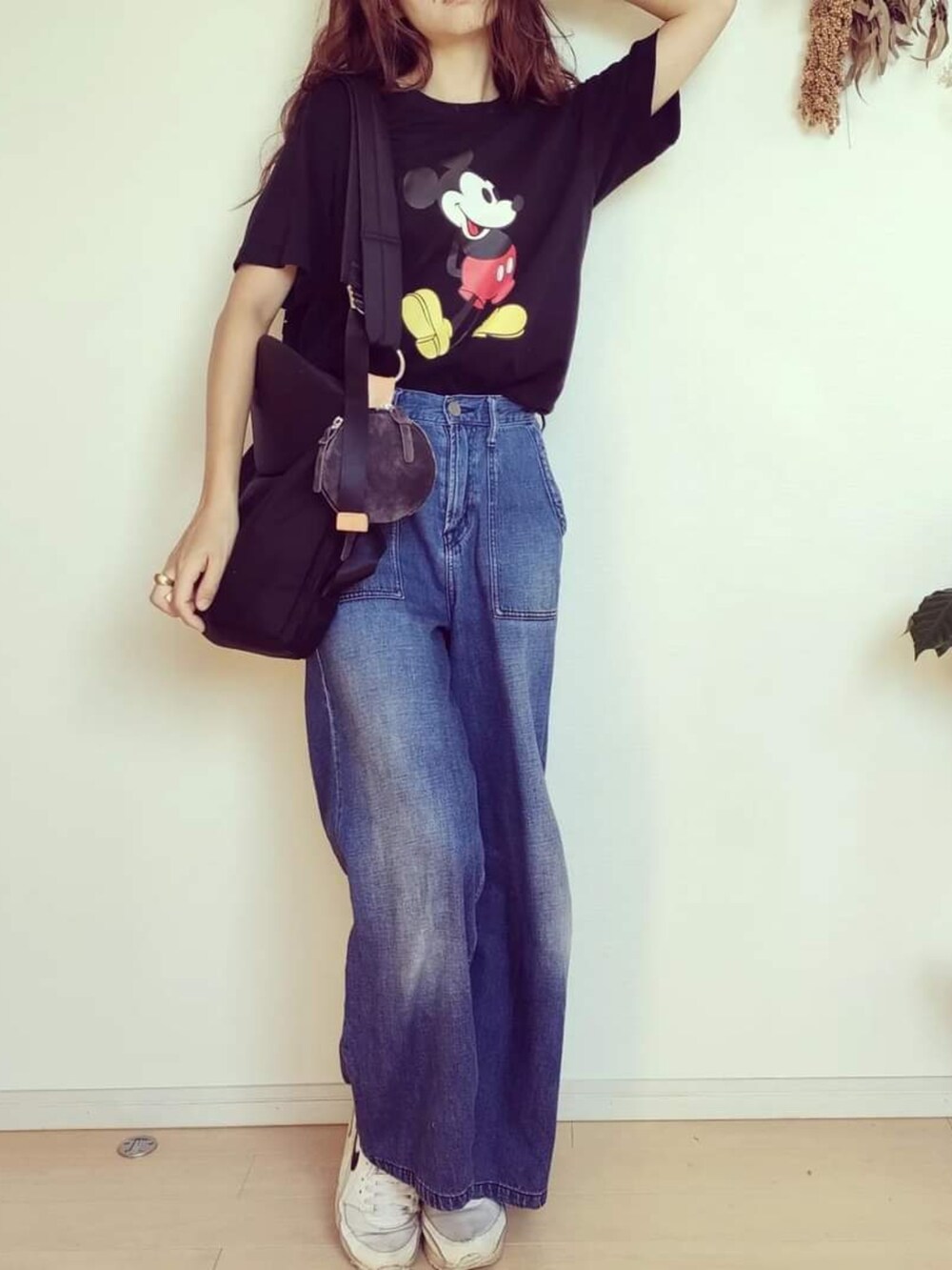 ブラック系のTシャツ/カットソー、ブルー系のデニムパンツ、ブラック系のバッグを着用したレディースの秋コーディネートの5枚目の写真