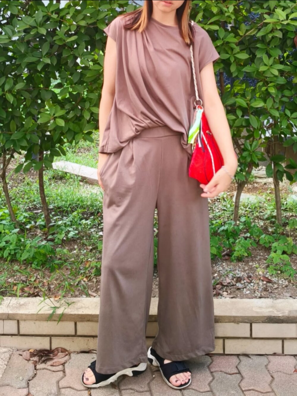 ブラウン系のTシャツ/カットソー、オレンジ系のショルダーバッグ、ブラック系のサンダルを着用したレディースの夏コーディネートの2枚目の写真