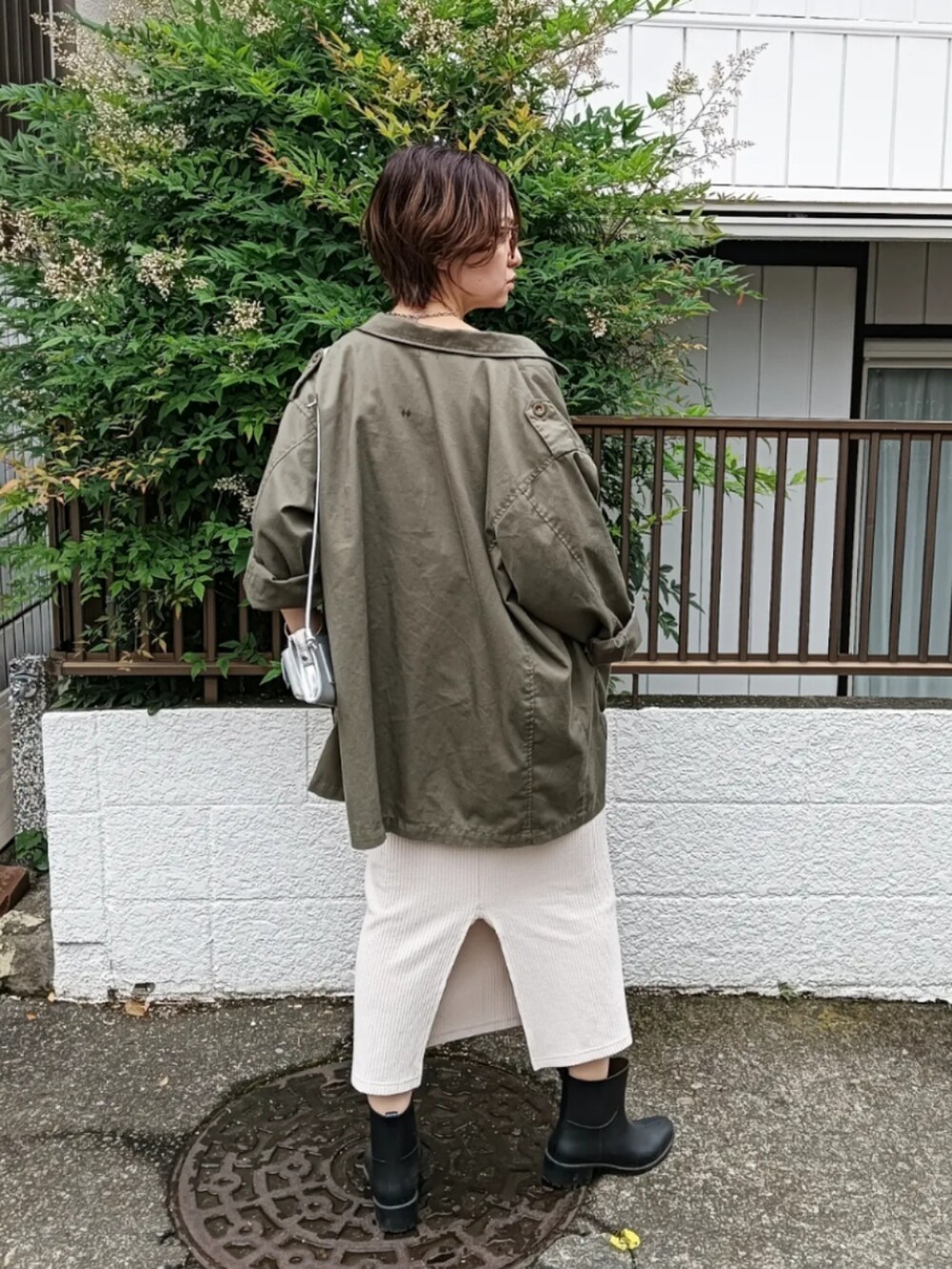 ブラック系のTシャツ/カットソー、グリーン系のミリタリージャケット、グレー系のショルダーバッグを着用したレディースの夏コーディネートの2枚目の写真