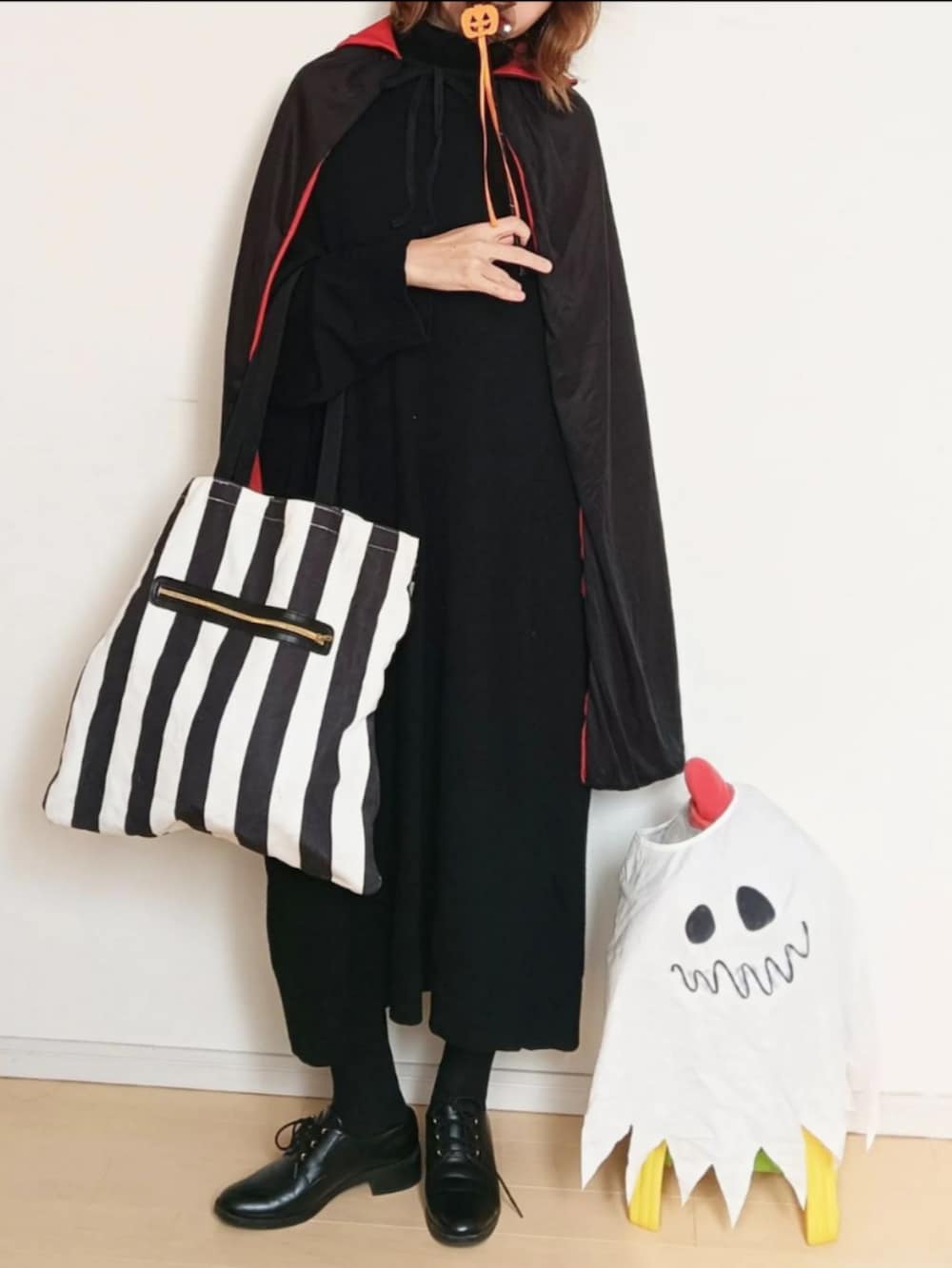 ブラック系のワンピース、ブラック系のトートバッグ、ブラック系のドレスシューズを着用したレディースの秋コーディネートの3枚目の写真