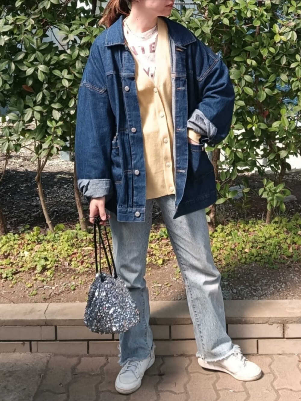イエロー系のTシャツ/カットソー、グリーン系のカーディガン/ボレロ、ブルー系のデニムジャケットを着用したレディースの春コーディネートの4枚目の写真