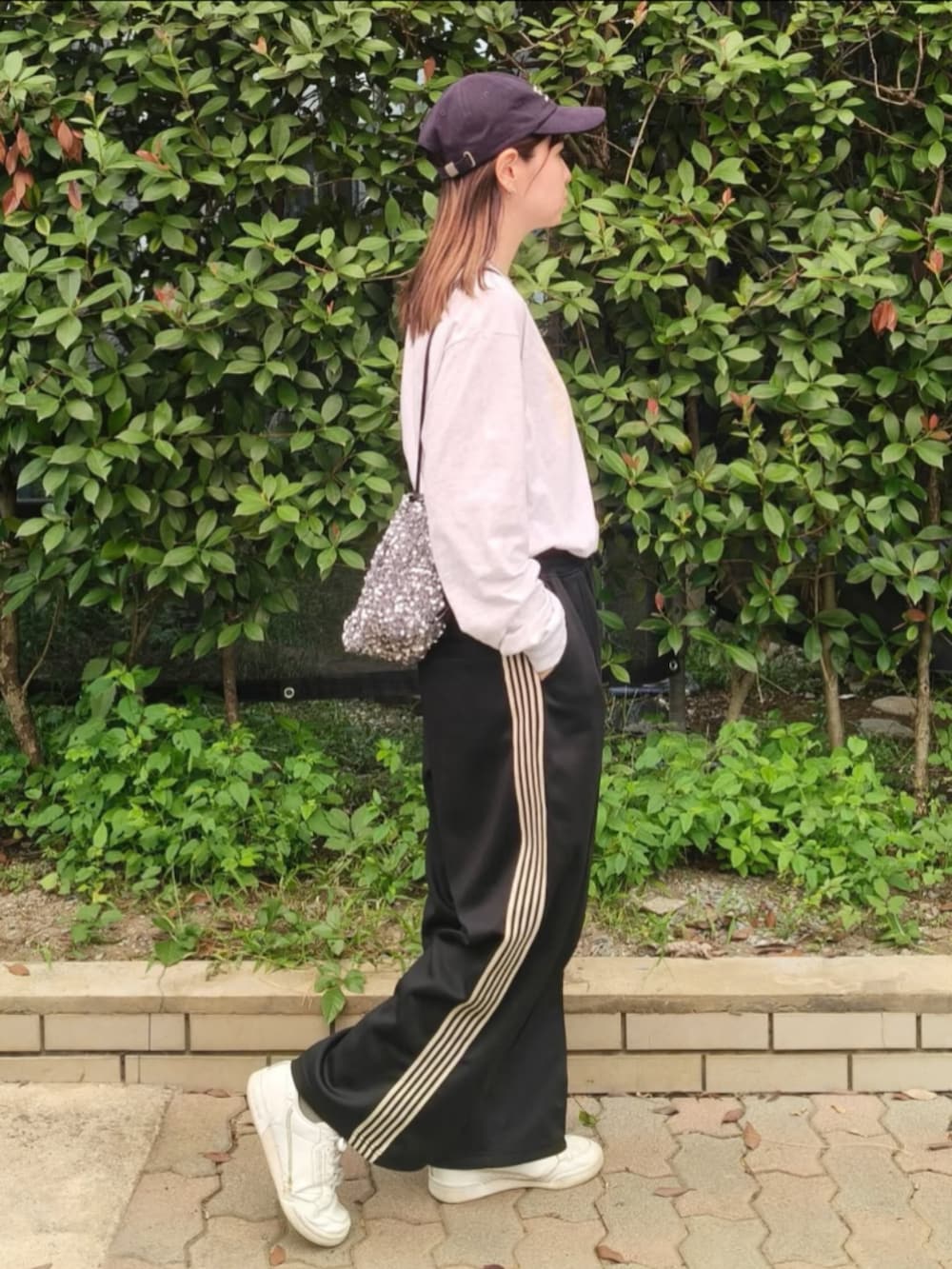 グレー系のTシャツ/カットソー、シルバー系のショルダーバッグ、ブラック系のその他パンツを着用したレディースの秋コーディネートの2枚目の写真