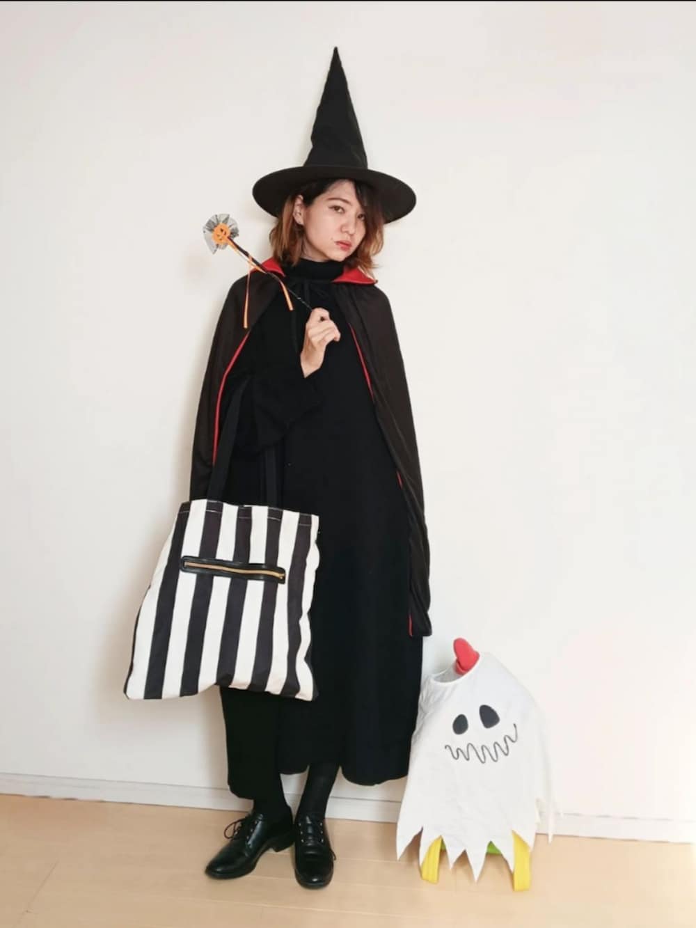 ブラック系のワンピース、ブラック系のトートバッグ、ブラック系のドレスシューズを着用したレディースの秋コーディネートの2枚目の写真