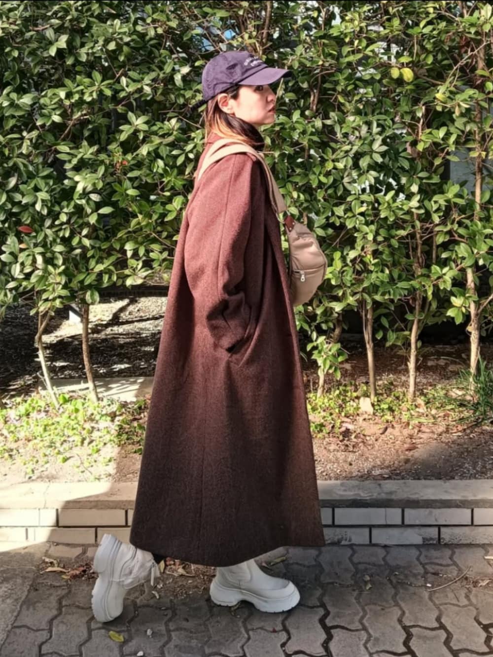 ベージュ系のショルダーバッグ、ブラウン系のその他アウター、ブラック系のワンピースを着用したレディースの冬コーディネートの2枚目の写真