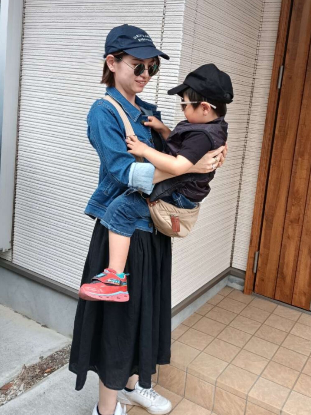 ブルー系のデニムジャケット、ベージュ系のショルダーバッグ、ホワイト系のスニーカーを着用したレディースの春コーディネートの4枚目の写真