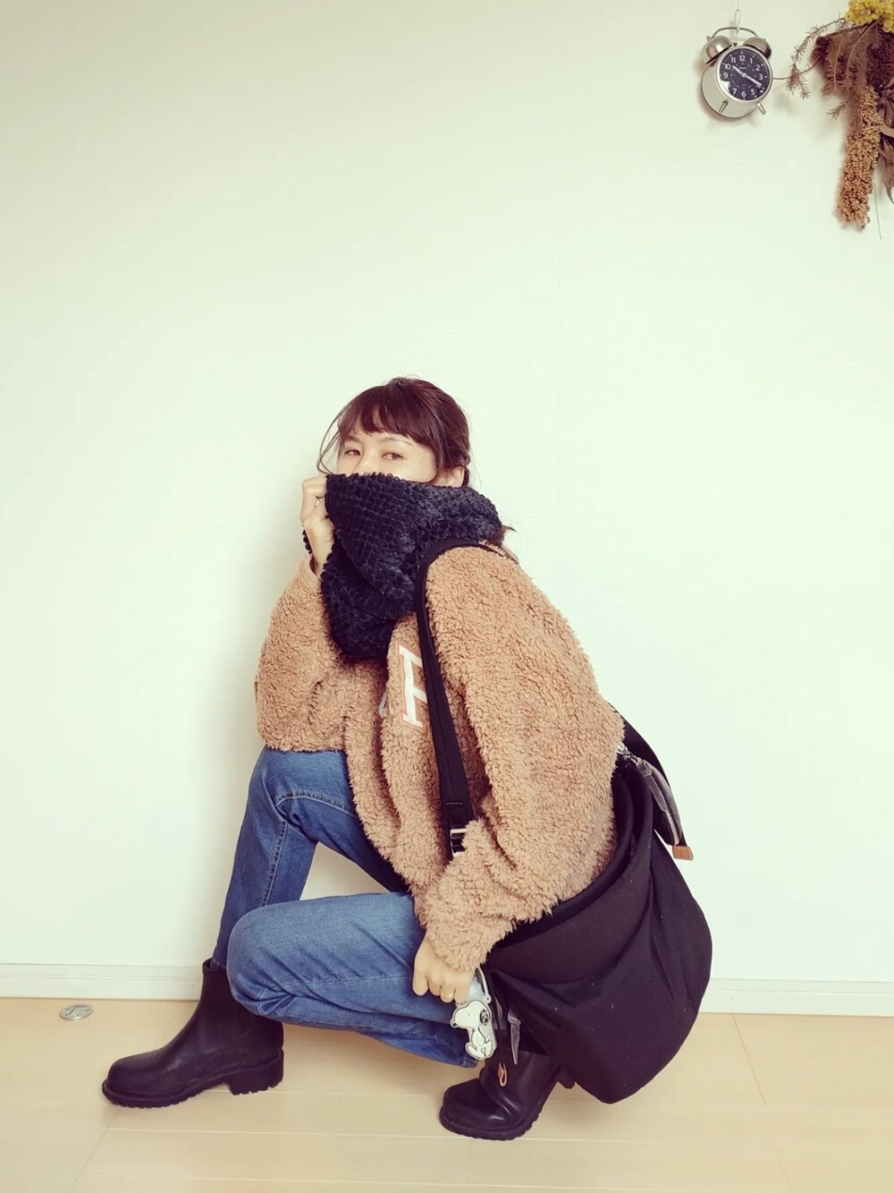 ブラック系のバッグ、ブラック系のレインシューズ、ブルー系のデニムパンツを着用したレディースの秋コーディネートの3枚目の写真