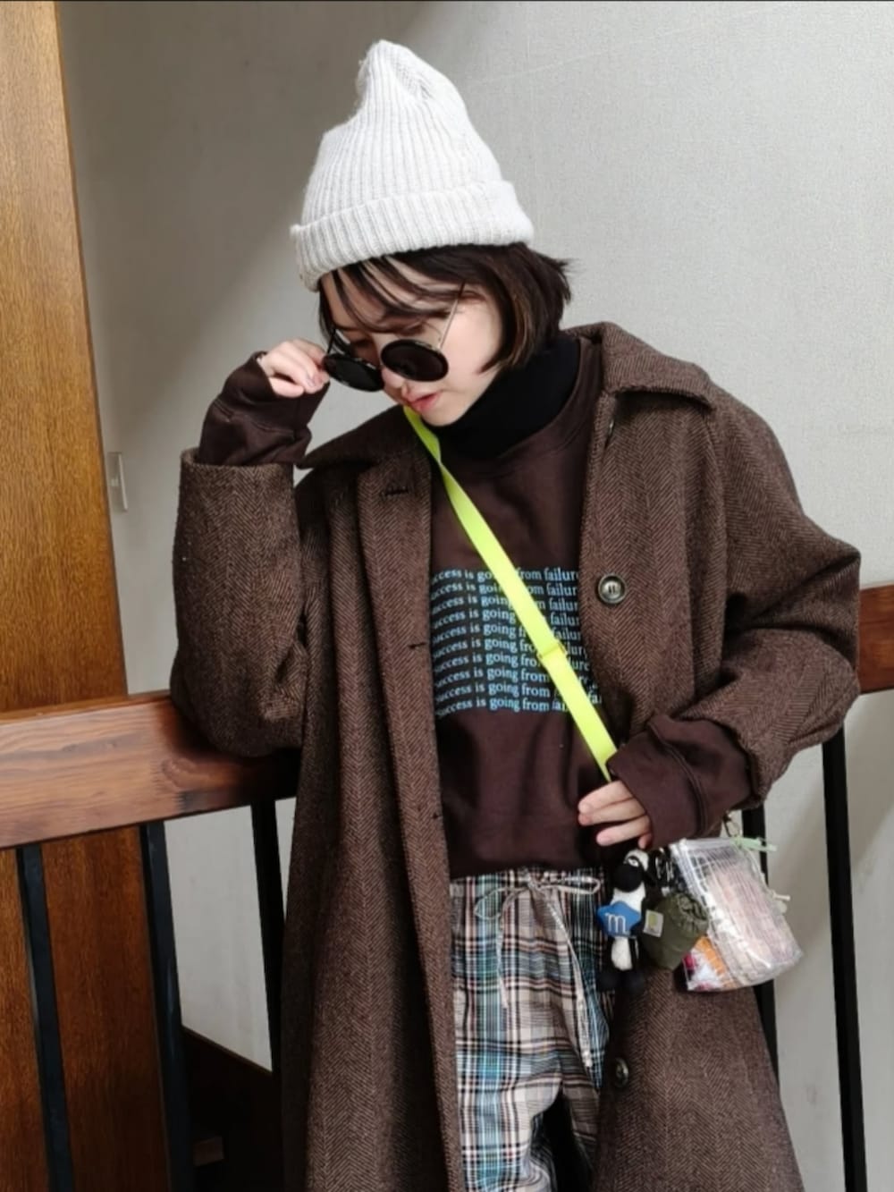 ブラウン系のスウェット、ブラウン系のその他アウター、ホワイト系のショルダーバッグを着用したレディースの冬コーディネートの3枚目の写真