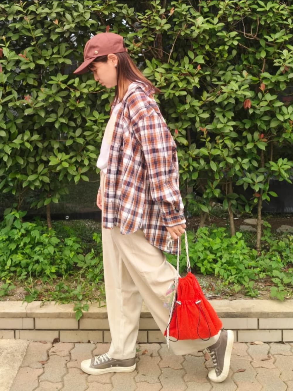 グレー系のTシャツ/カットソー、レッド系のシャツ/ブラウス、ホワイト系のスラックスを着用したレディースの秋コーディネートの4枚目の写真