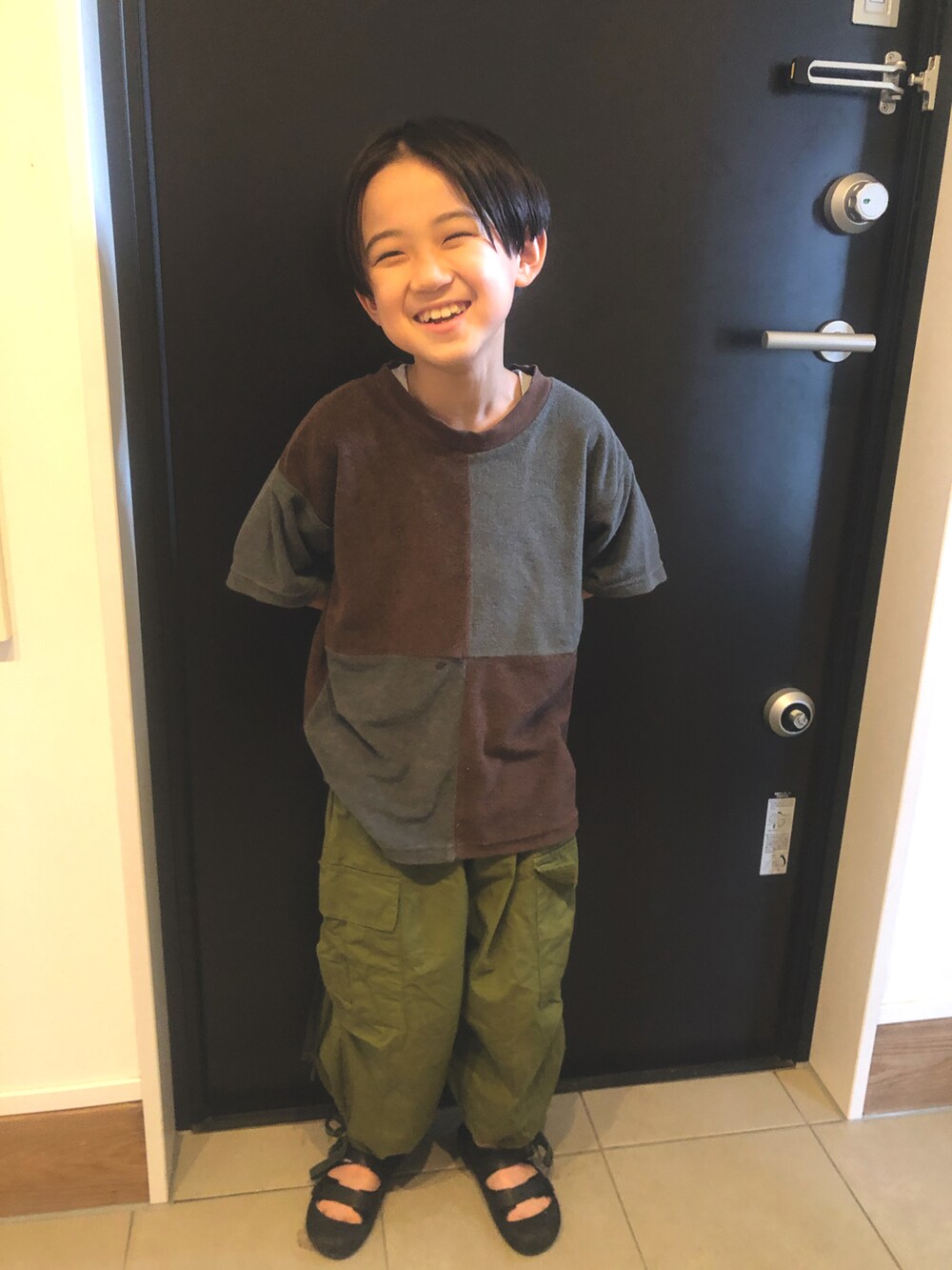 ブラック系のサンダル、ブラウン系のTシャツ/カットソーを着用したキッズの夏コーディネートの2枚目の写真