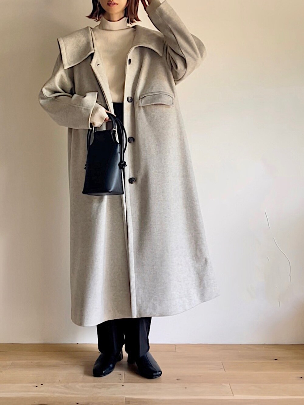 ベージュ系のステンカラーコート、ベージュ系のニット/セーター、ブラック系のその他パンツを着用したレディースの秋コーディネートの2枚目の写真