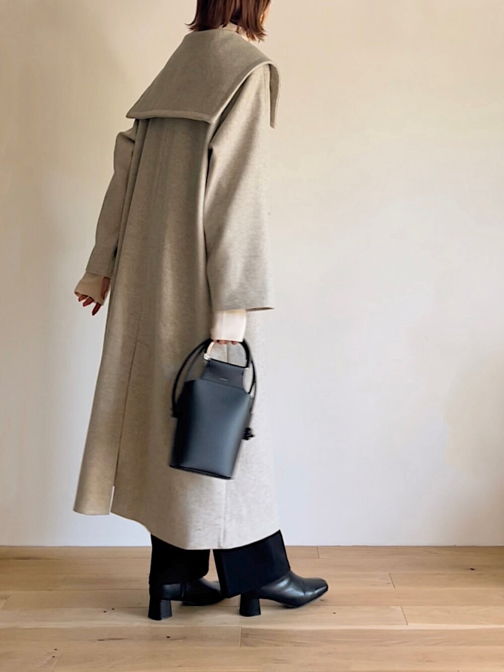 ベージュ系のステンカラーコート、ベージュ系のニット/セーター、ブラック系のその他パンツを着用したレディースの秋コーディネートの4枚目の写真