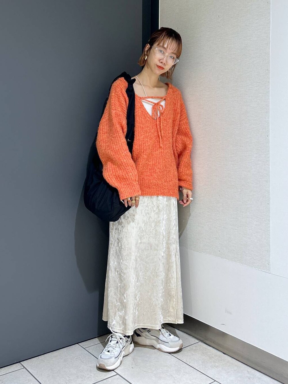 ホワイト系のタンクトップ、オレンジ系のニット/セーター、ホワイト系のスカートを着用したレディースの秋コーディネートの2枚目の写真