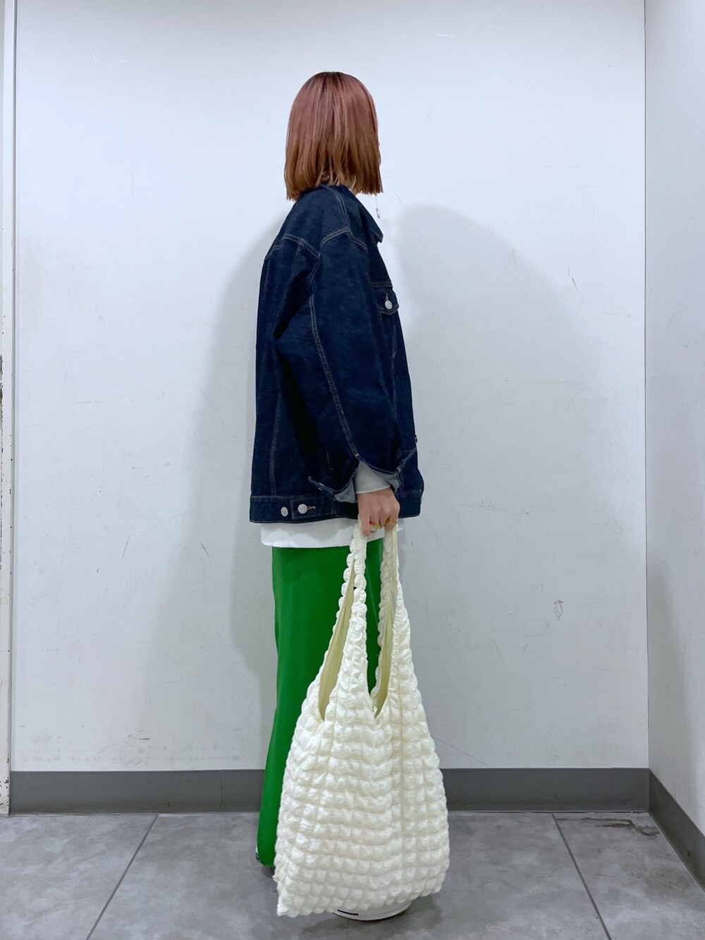 ブルー系のノーカラーコート、ホワイト系のスウェット、ホワイト系のニット/セーターを着用したレディースの冬コーディネートの3枚目の写真