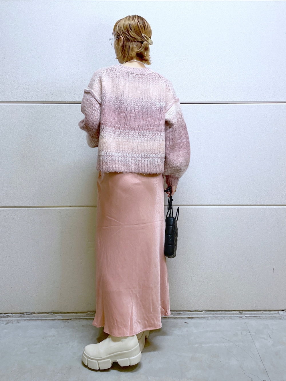 ホワイト系のシューズ、ピンク系のニット/セーター、ピンク系のスカートを着用したレディースの秋コーディネートの2枚目の写真