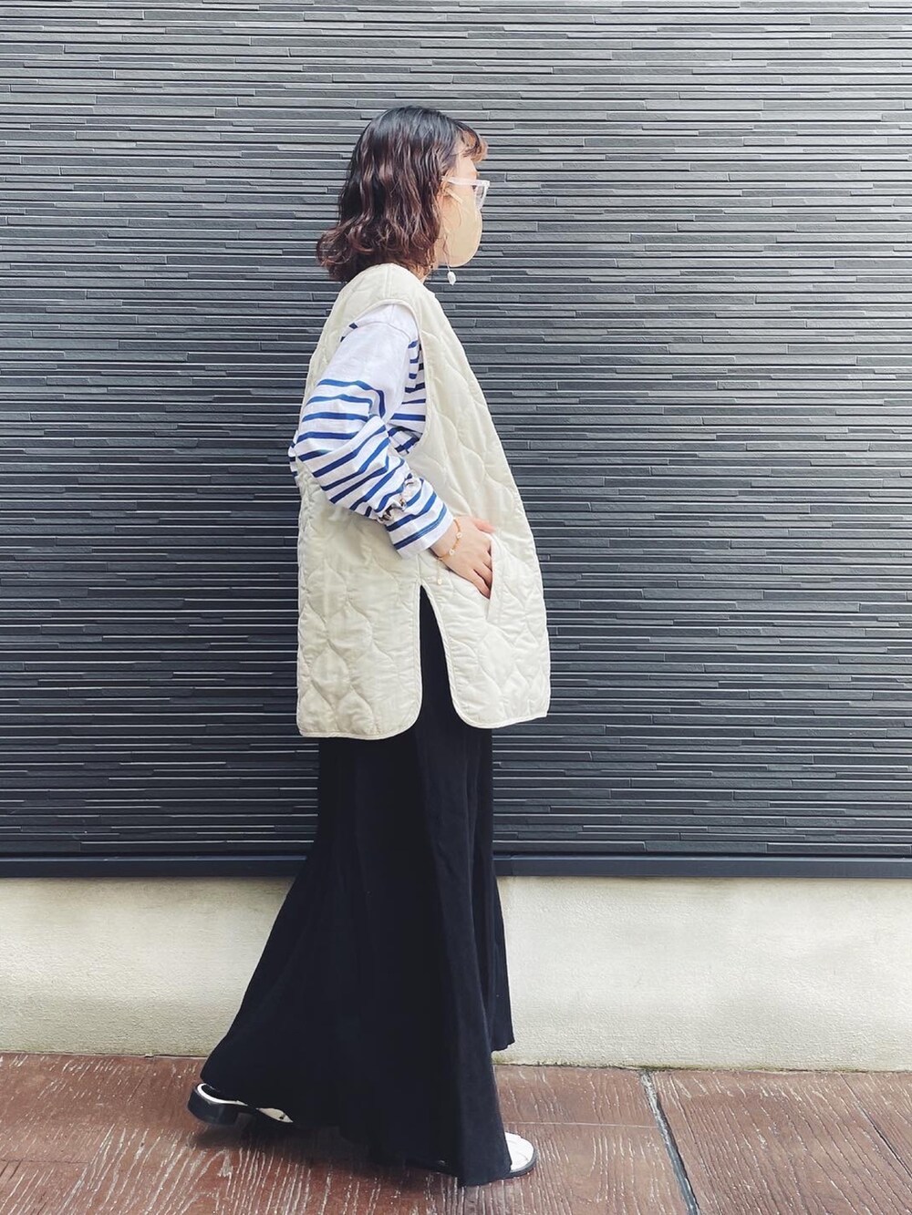 ブルー系のTシャツ/カットソー、ブラック系のスカート、ホワイト系のサンダルを着用したレディースの春コーディネートの2枚目の写真