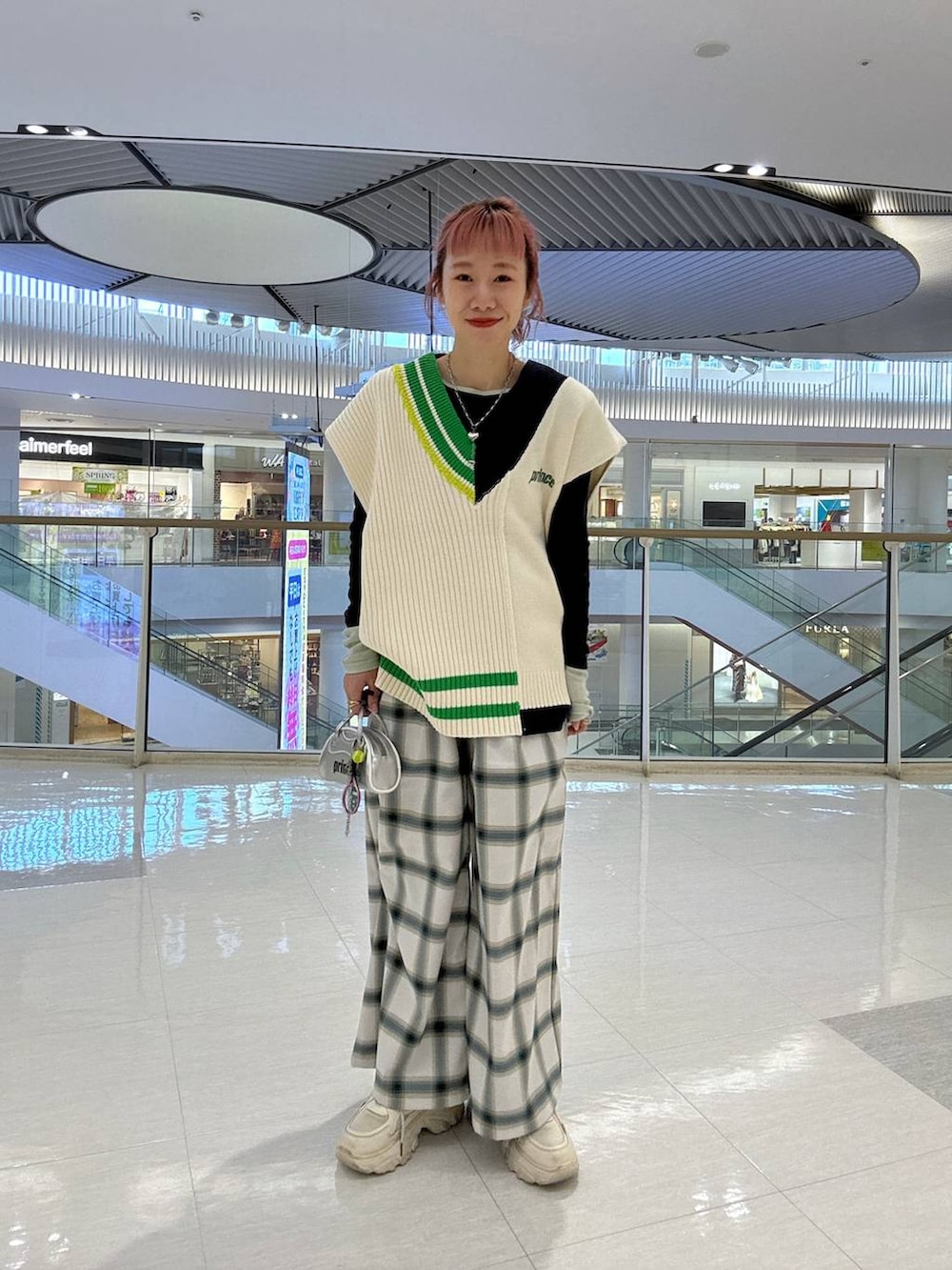 グレー系のTシャツ/カットソー、ホワイト系のサロペット/オーバーオール、ホワイト系のニット/セーターを着用したレディースの冬コーディネートの3枚目の写真