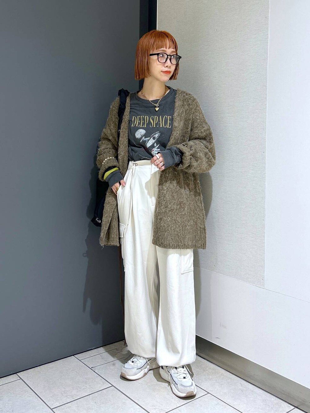 ホワイト系のトートバッグ、ブラック系のその他パンツ、ブラック系のブーツを着用したレディースの秋コーディネートの9枚目の写真